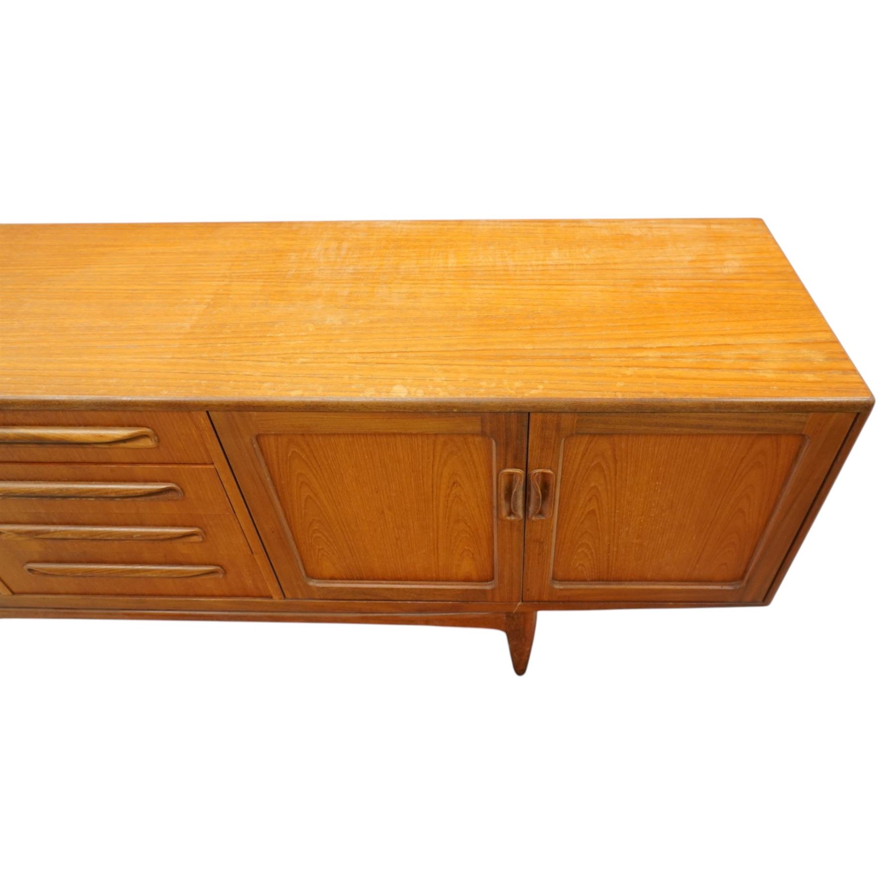 G-Plan - 'Fresco Long John' teak mid 20th century sideboard, a central bank of four drawers, flanked by twin cupboard doors, with recessed handles, on a tapering supports 