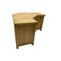 Oak twin pedestal corner desk, one pedestal fitted with single drawer over panelled cupboard door, the other with single cupboard
