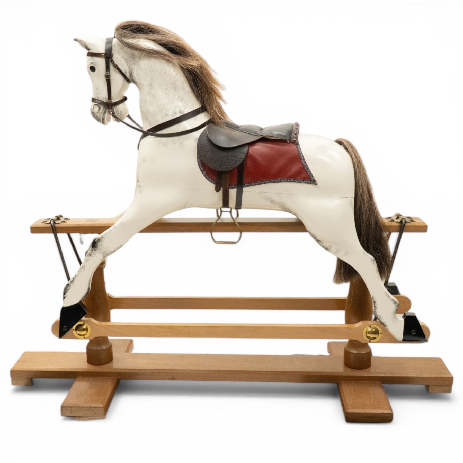 Late 20th century polychrome painted rocking horse, modelled in dapple grey finish with real hair mane and tail, leather tack and saddle, stirrups, raised on a natural wood safety trestle base