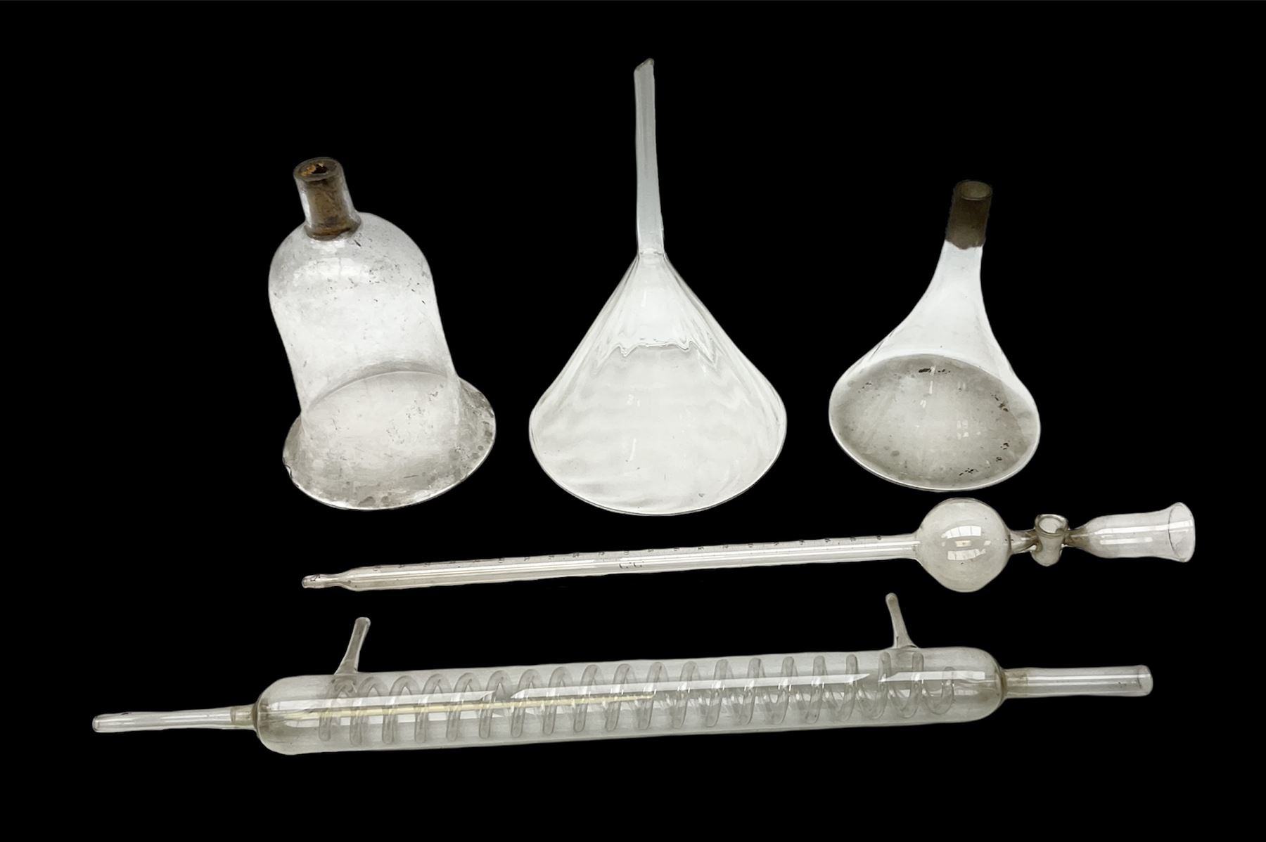Collection of 19th century and later pharmaceutical laboratory glass, to include, large filter funnel, graham condenser, conical flask, bell jar and another with graduated tube, Provenance: discovered in the storeroom of a long established Hull pharmacist and opticians
