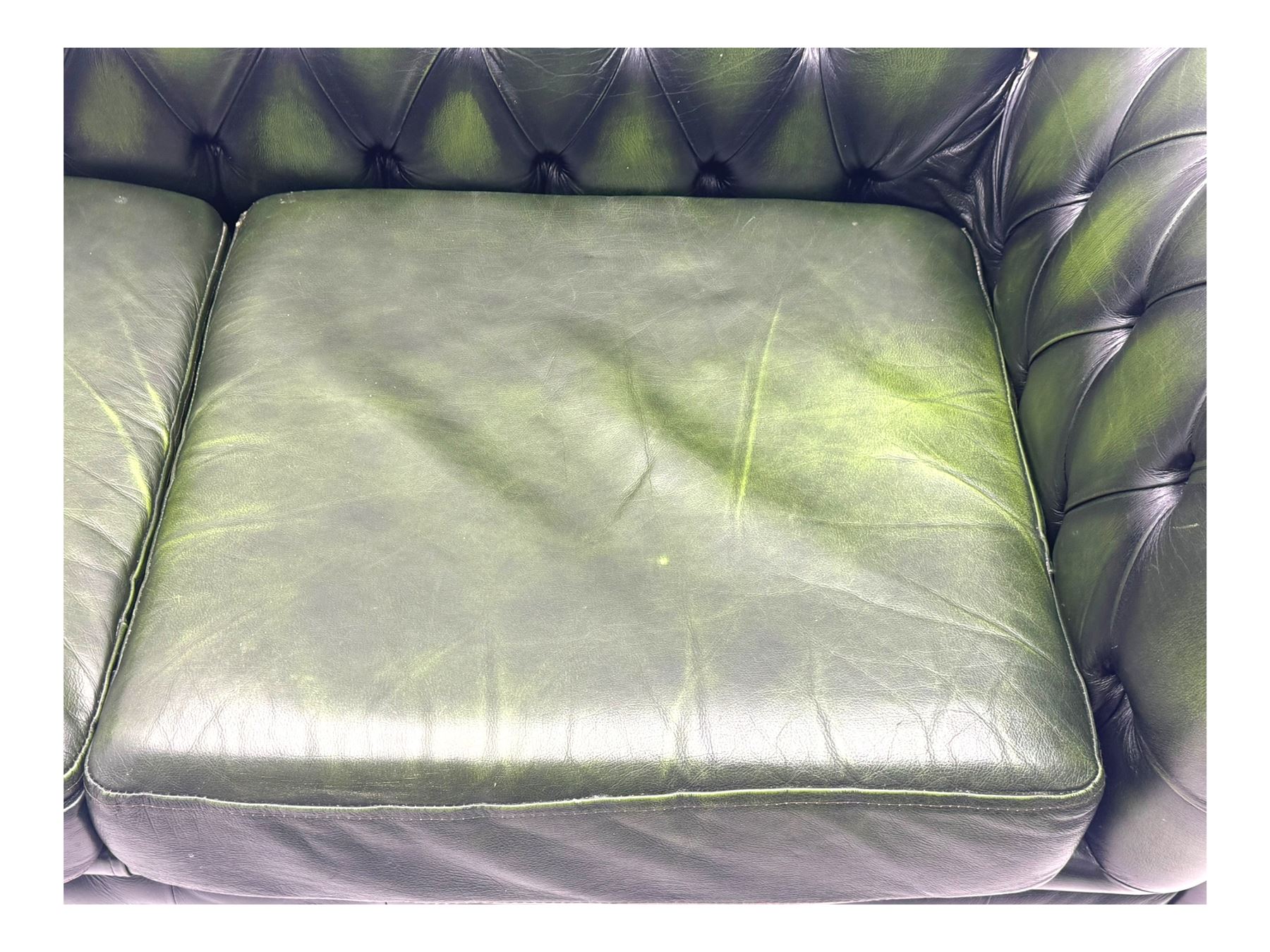Two seat Chesterfield design sofa bed, upholstered in emerald green leather with deep-buttoned detailing, rolled arms, two loose seat cushions, and pull-out 