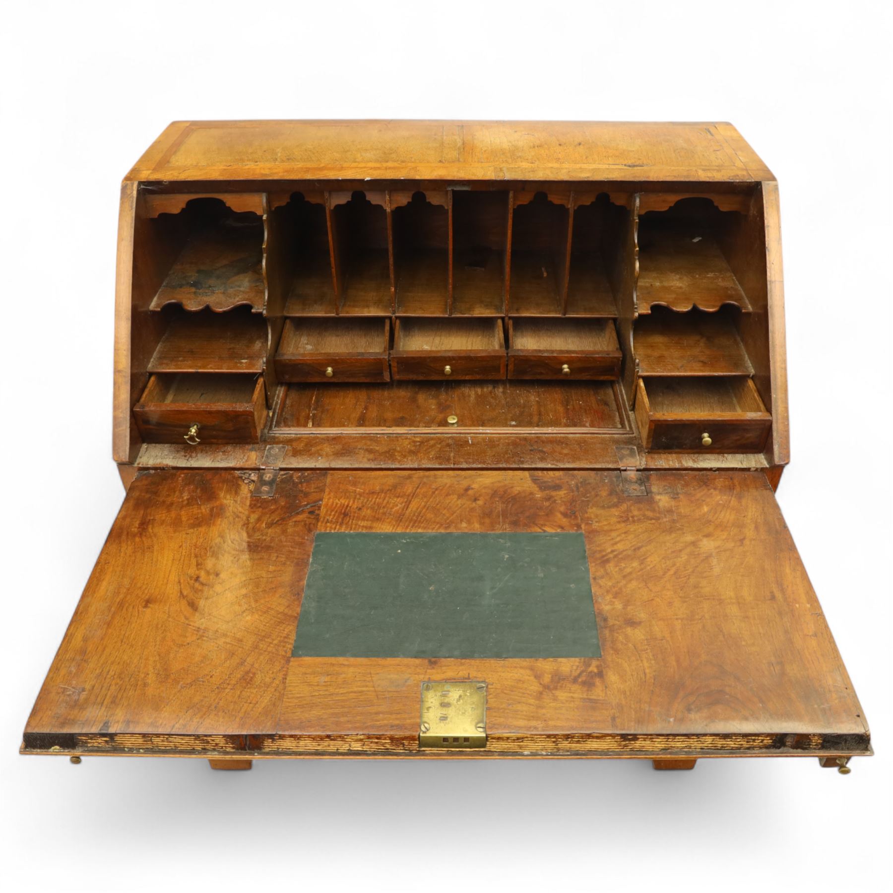 18th century walnut and herringbone banded bureau, the fall front enclosing a stepped and arched interior fitted with pigeonholes, drawers and concealed compartments, green tooled leather writing surface, over two short and three long graduated drawers with brass escutcheons and bail handles, shaped bracket feet