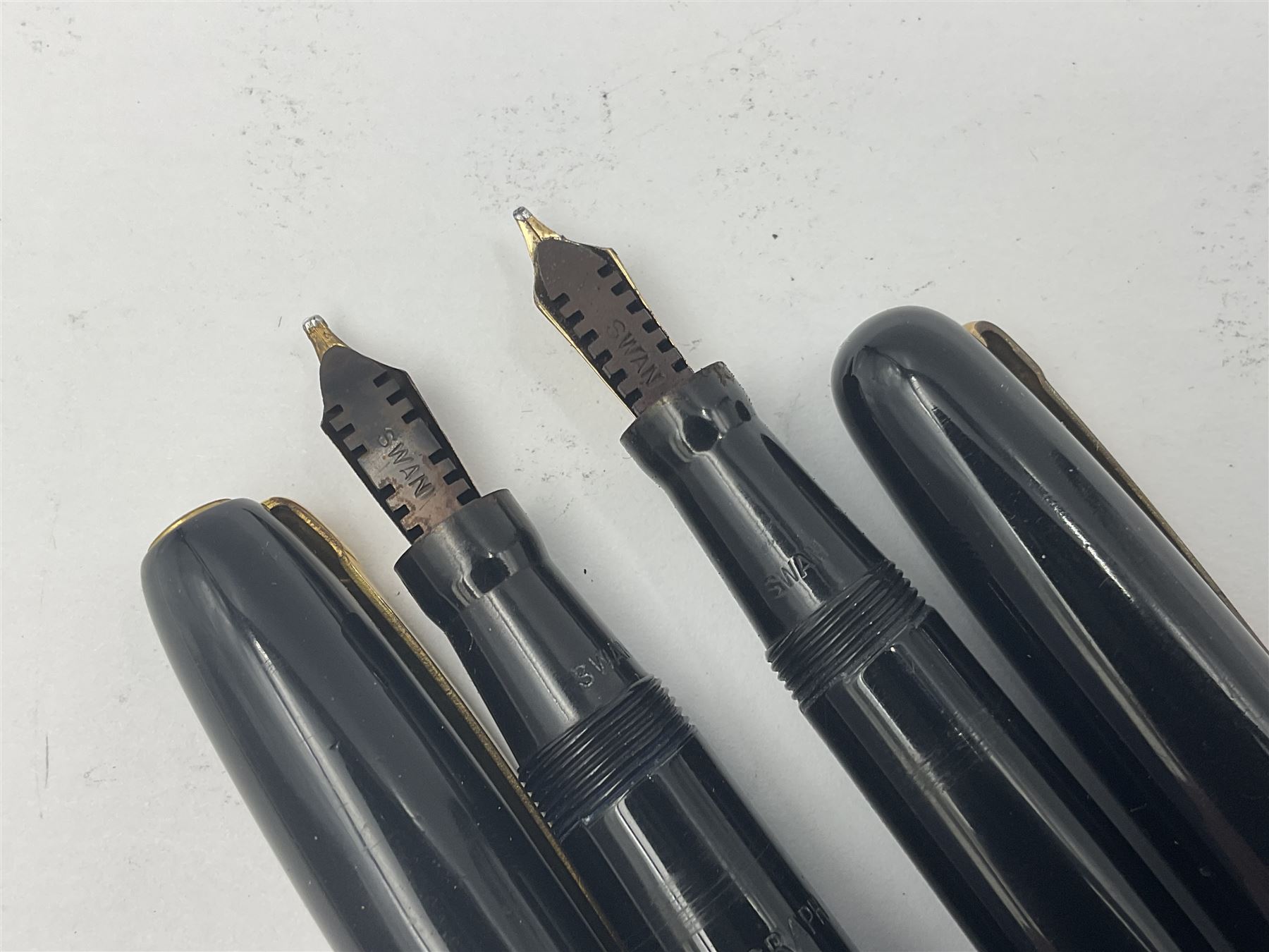 Three Swan Mabie Todd fountain pens, comprising Self Filler 3162 with black barrel and cap with single band and gold nib stamped Eternal 1 14ct, together with two Calligraph examples with gold nibs stamped 14ct, one with box, largest L12.5cm