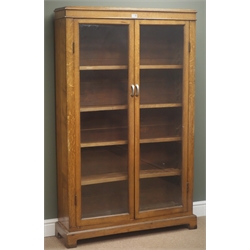 Early 20th century oak bookcase, two bevelled glass doors, four adjustable shelves, bracket supports, W100cm, H159cm, D29cm  
