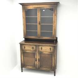  20th century oak side cabinet with glazed top above two drawers and two doors on turned supports, W107cm, H202cm, D49cm  