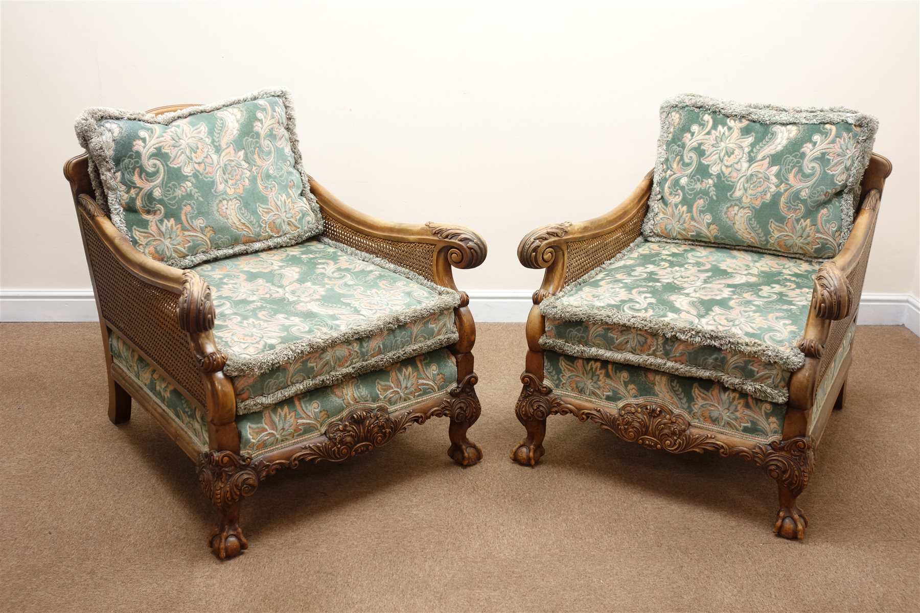 Early 20th century walnut framed bergere suite, the acanthus carved outsplayed arms with double