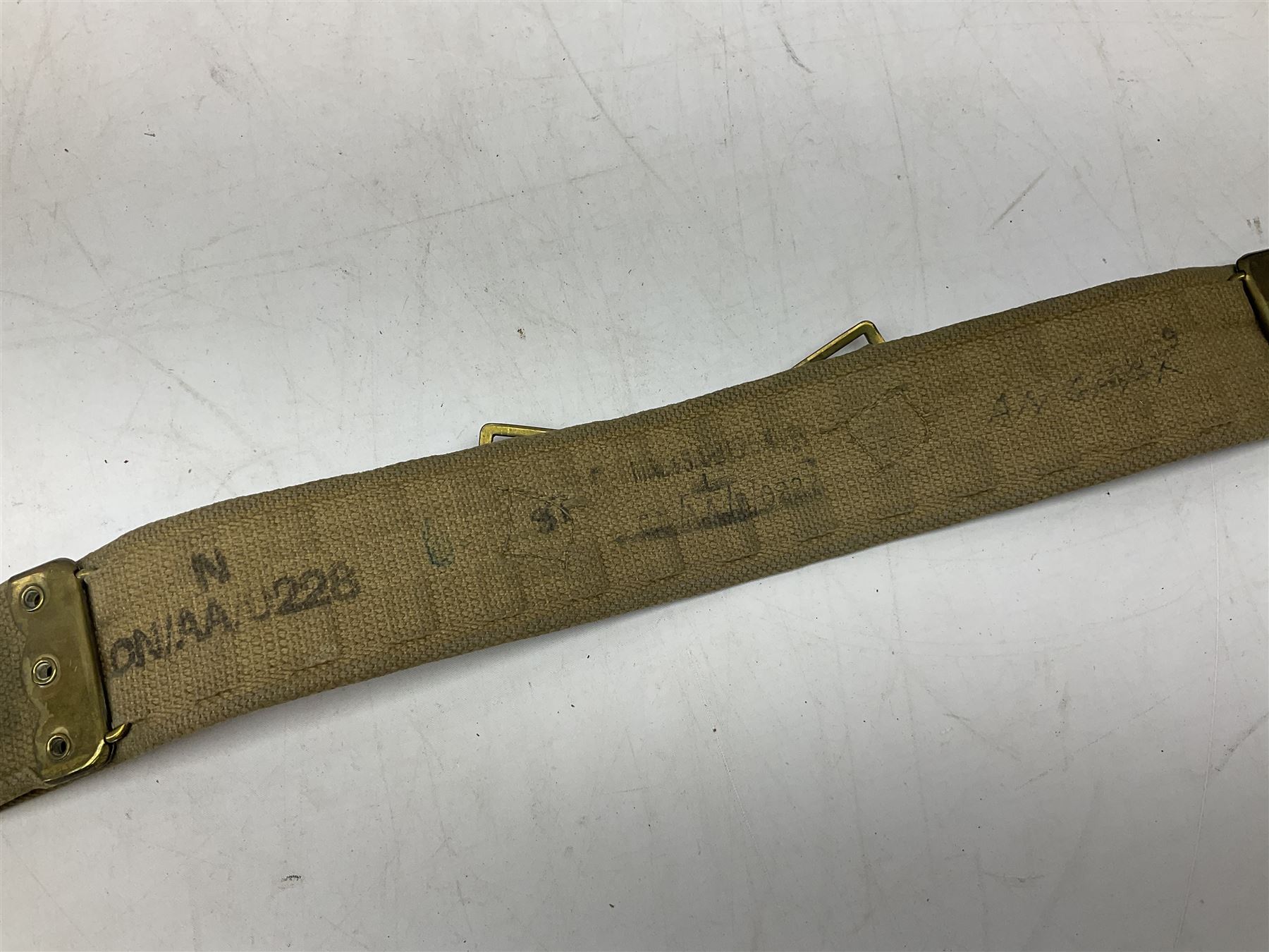 British Army Officers Sam Browne leather belt with shoulder strap; and webbing belt with Potter London Staybrite buckle for 19th Regiment of Foot (Green Howards) with various markings (2)