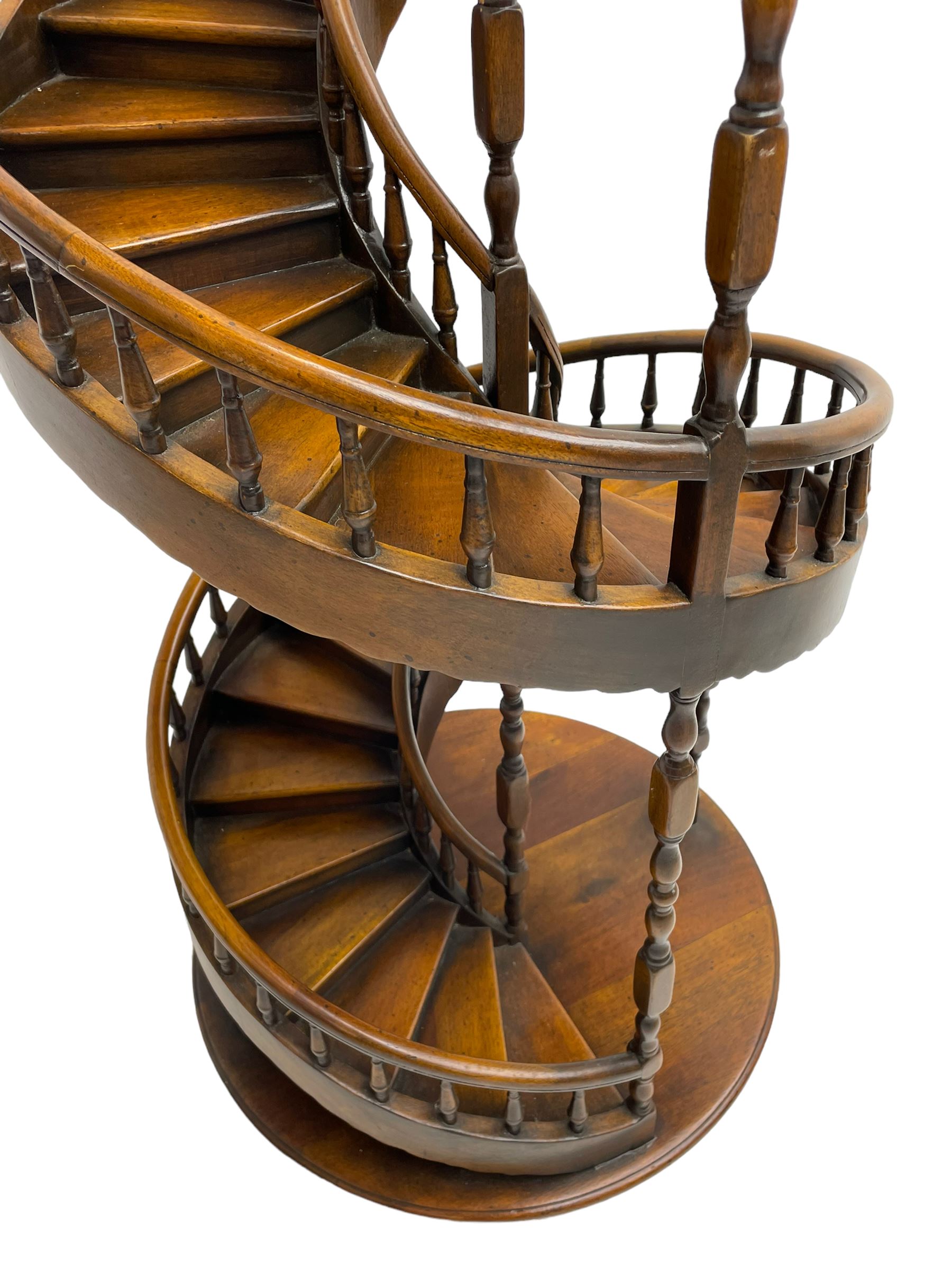 Miniature fruitwood spiral staircase, turned newel posts and balusters, rounded handrail, on circular moulded base