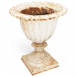 Pair of Victorian white painted cast iron lotus garden urns on stop fluted and lobed plinth bases