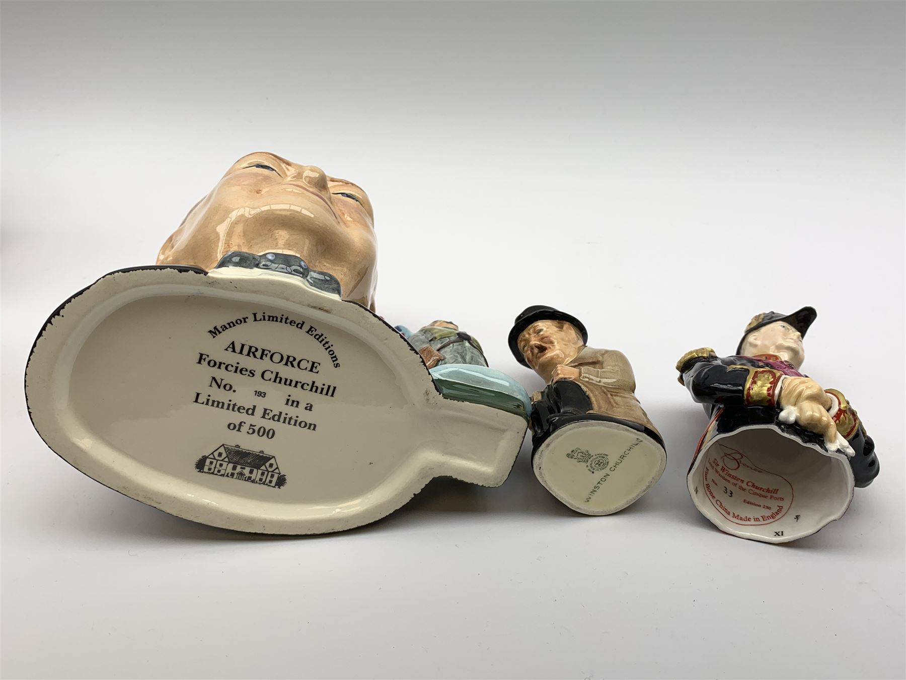 Collection of Winston Churchill figures, to include three graduated Royal Doulton toby jugs, Manor Limited Editions Forcies Churchill character jug, Bairstow Manor Pottery Bust, Bronte Sir Winston Churchill Lord Warden of the Cinque Ports snuffer, etc., together with two pieces of Crested ware. (10).