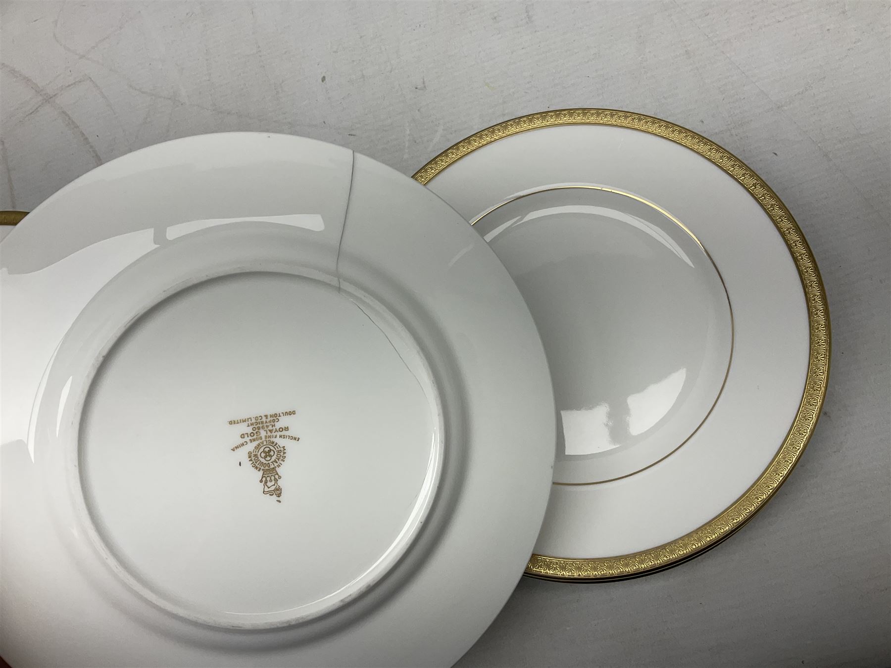 Royal Doulton Royal Gold pattern tea and dinner service for eight, comprising dinner plates, side plates, tea plates, soup bowls, sauce boat and saucer, dessert bowls, coffee cans and saucers, teacups and saucers and two lidded tureens