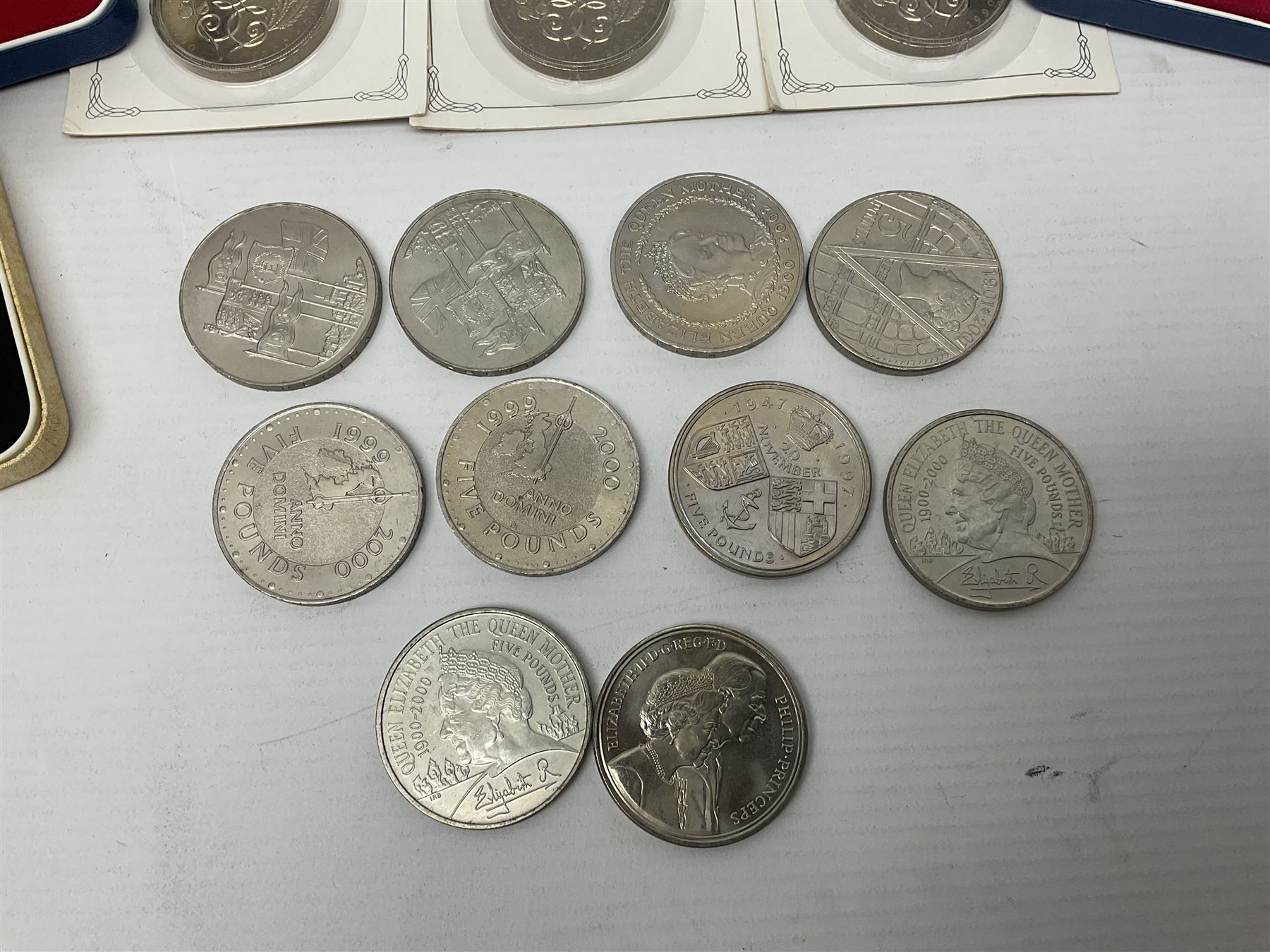 Queen Elizabeth II 1977 silver crown and 1980 silver crown, both cased with certificates, Bailiwick of Guernsey 1978 silver crown cased without certificate, three United Kingdom brilliant uncirculated five pound coins in card folders and twelve other five pound coins