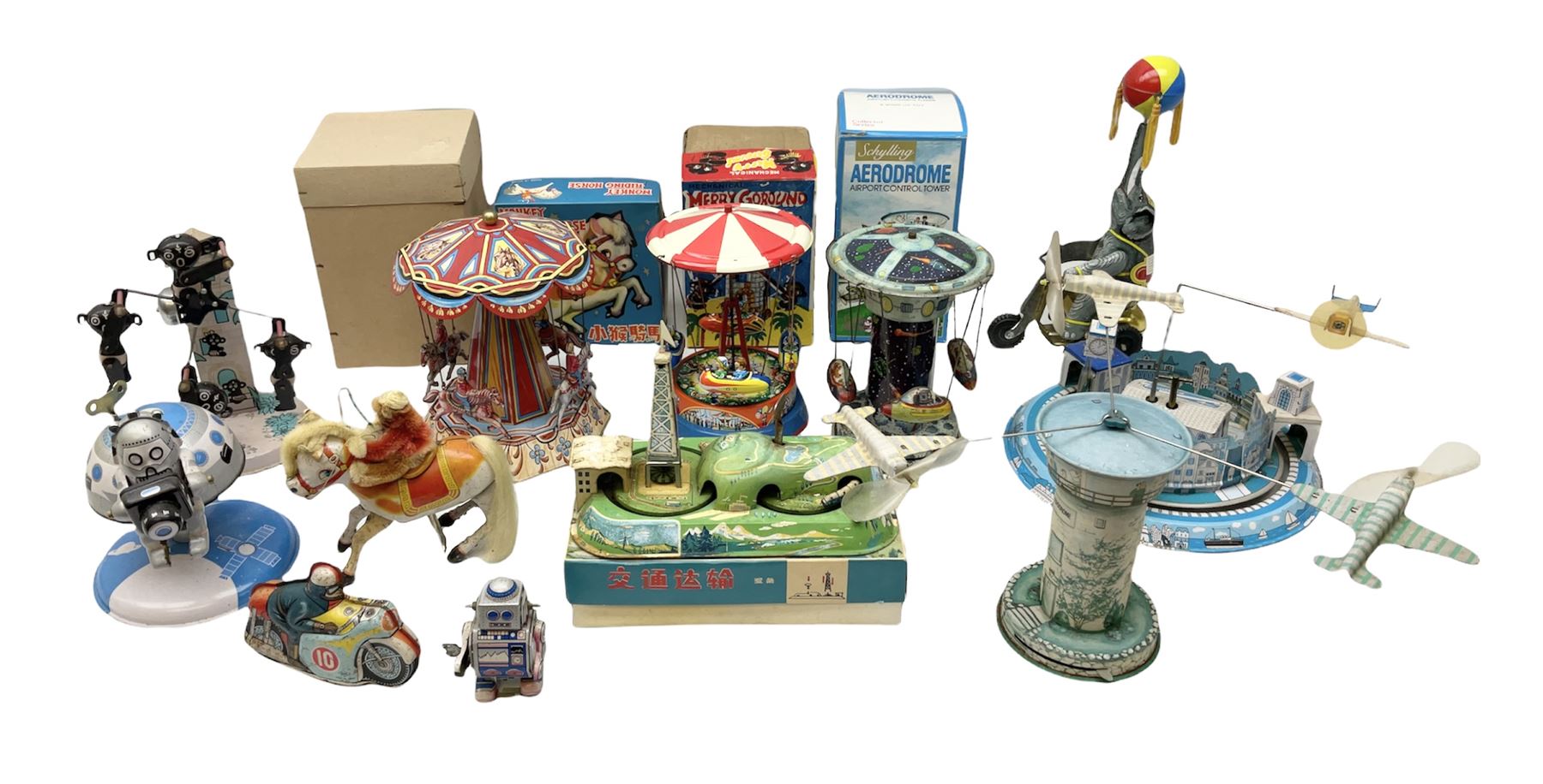 Mid 20th century and later tin plate clockwork toys, to include merry-go-rounds, spaceship carousel, walking robot, Schylling airport control tower, monkey riding horse, astronaut space station etc, including German and Japanese examples, some with boxes (12)