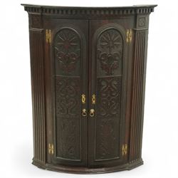 18th century oak bow front corner cupboard, the twin panelled doors with arched and foliat...