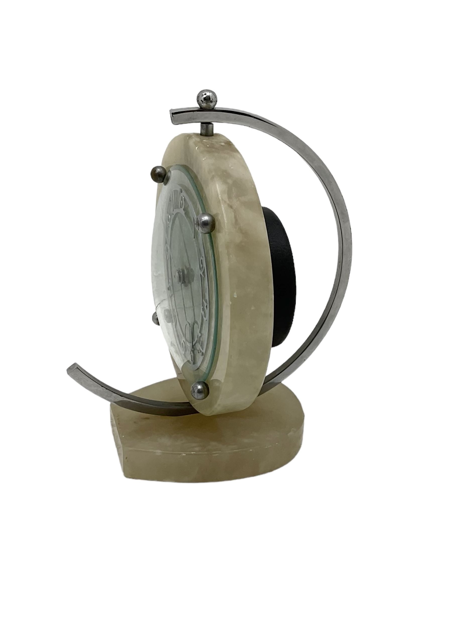 English 1920's Art Deco white-onyx mantel clock c1920, with a circular marble surround,  glass fronted chrome plated chapter with fretted Arabic numerals and conforming hands, movement and dial suspended in a semi-circular swivel gimbal mount, spring driven movement with a balance escapement, wound and set from the rear.