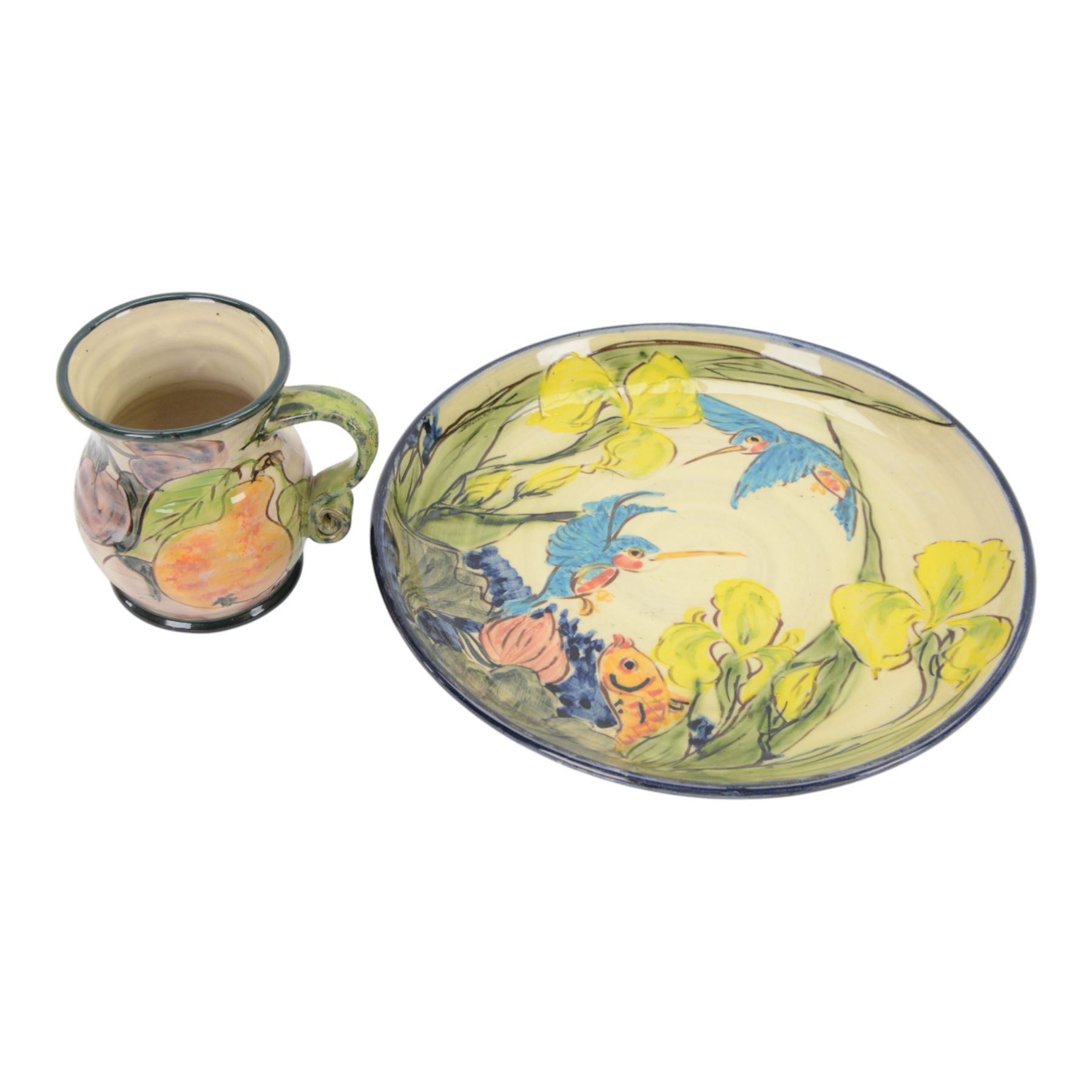 Paul Jackson Studio Pottery dished plate, decorated with Kingfishers and Koi fish amongst yellow irises, D26cm, together with a Paul Jackson Studio Pottery mug, of bellied form decorated with fruits, H11cm, each signed and dated 1996 and 1994