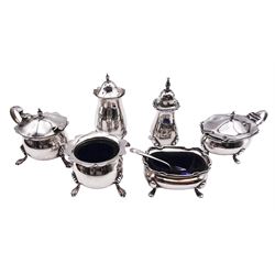 Early 20th century silver three piece cruet set, comprising open salt with blue glass liner, mustard pot and cover with blue glass liner, pepper, each with castellated rim, and two cruet spoons, hallmarked Walker & Hall, Sheffield 1913, 1914, 1915, and 1916, together with a similar set, hallmarked Birmingham 1918 and 1919, plus a further cruet spoon, approximate total silver weight 7.83 ozt (243.5 grams)