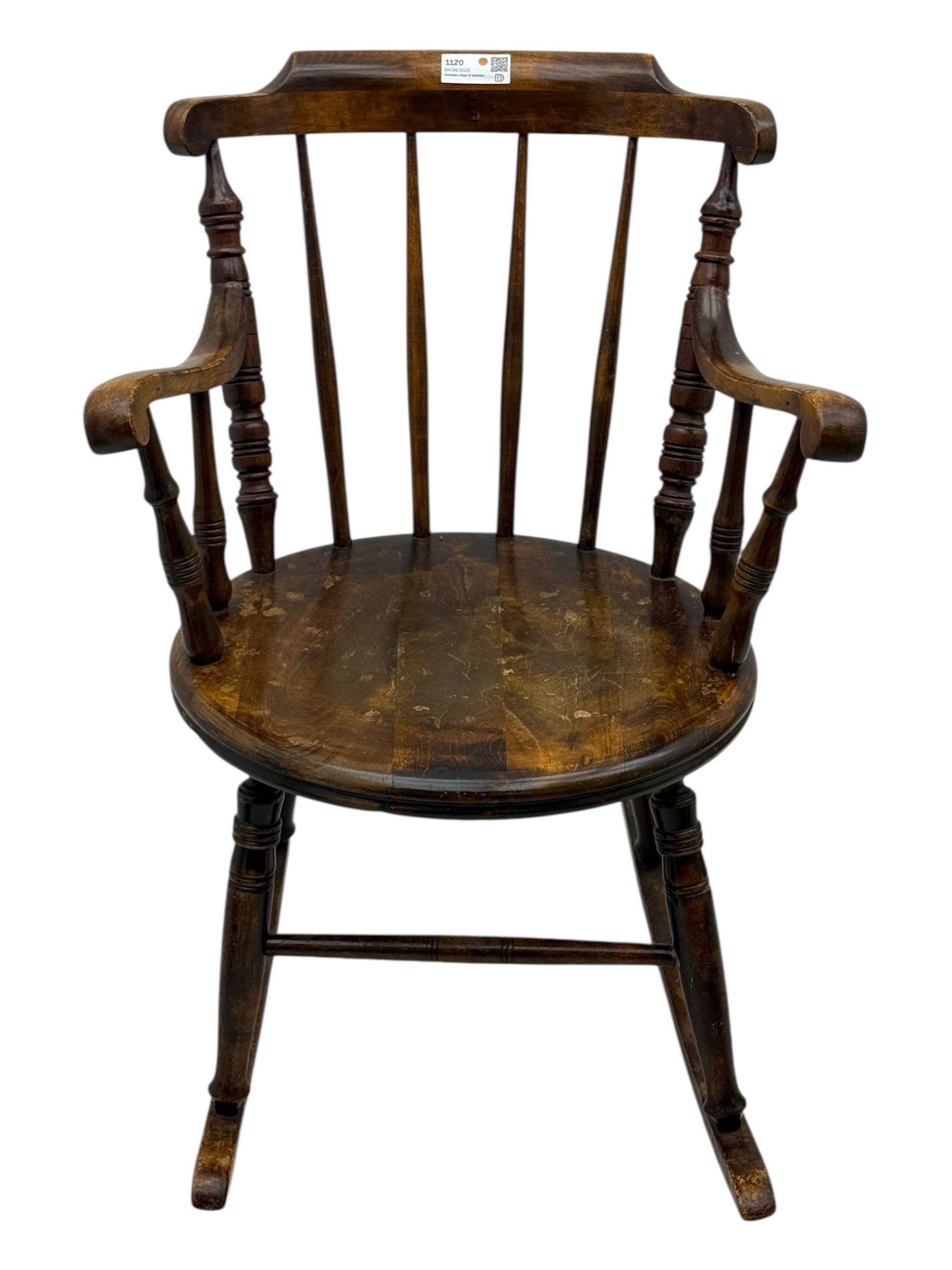 Late 19th century elm and beech Windsor rocking chair, with shaped top rail over turned spindles and curved arms, circular seat raised on turned legs united by stretcher on rockers