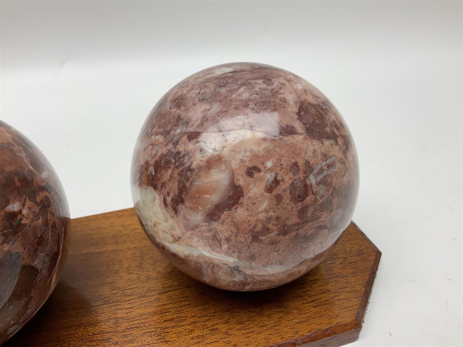 Set of three marble spheres on a elongated octagonal wooden base, H12cm