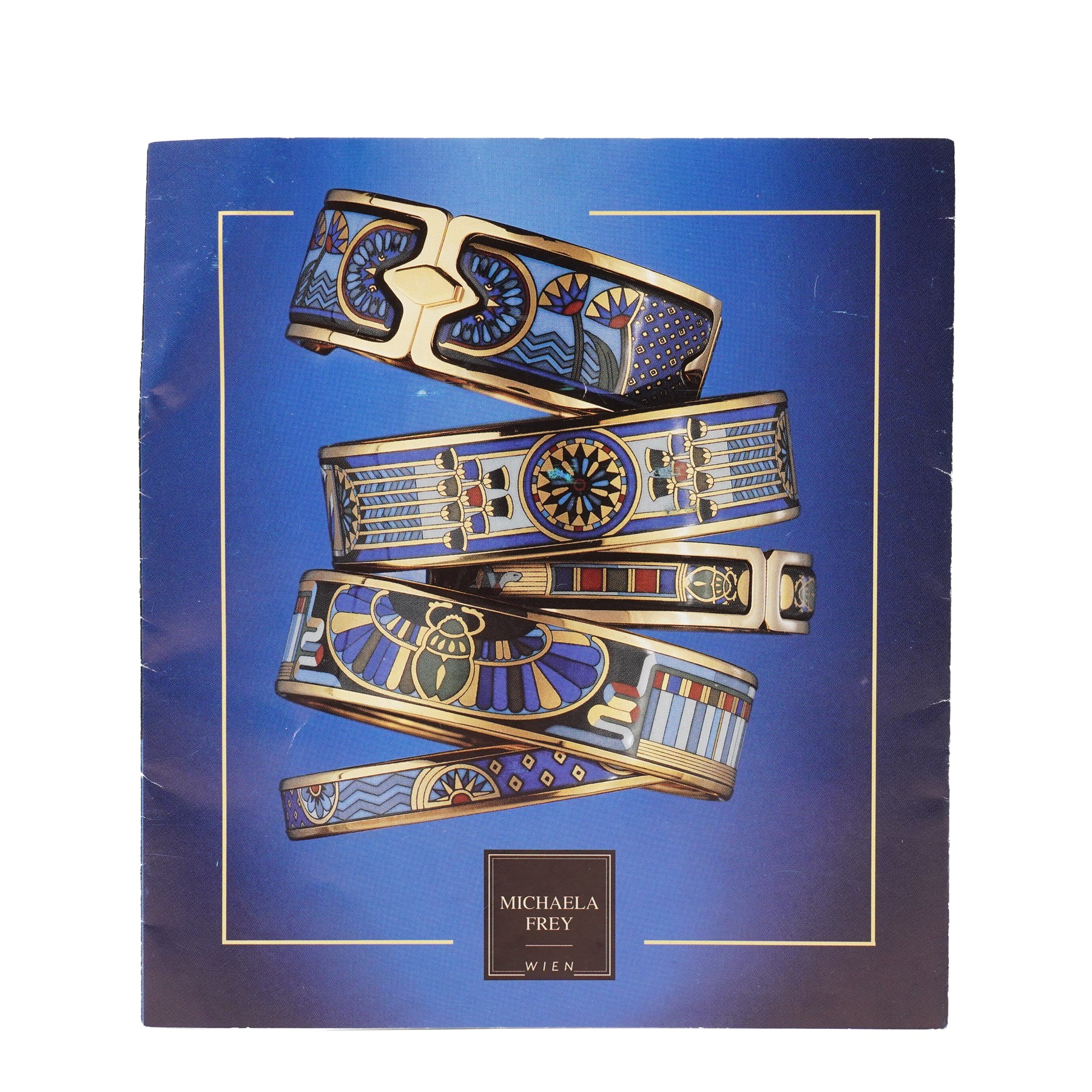 Michaela Frey gold plated and enamel suite of jewellery from the Greco-Roman collection, including a pair of oval stud earrings, hinged bangle and pendant on multistrand rope necklace, all boxed