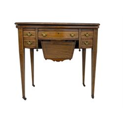 Edwardian inlaid mahogany games or work table, rectangular fold-over top inlaid with stylised dragon ivorine decoration and stringing, fitted with one long flanked by four small drawers over sewing compartment drawer, raised on square tapering supports with castors