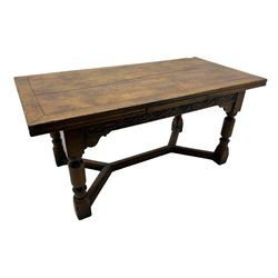 Early 20th century Jacobean design draw-leaf oak dining table, rectangular top with carved frieze depicting scrolling foliage and grape clusters, sliding extending leaves, raised on robust turned supports united by H-stretcher  