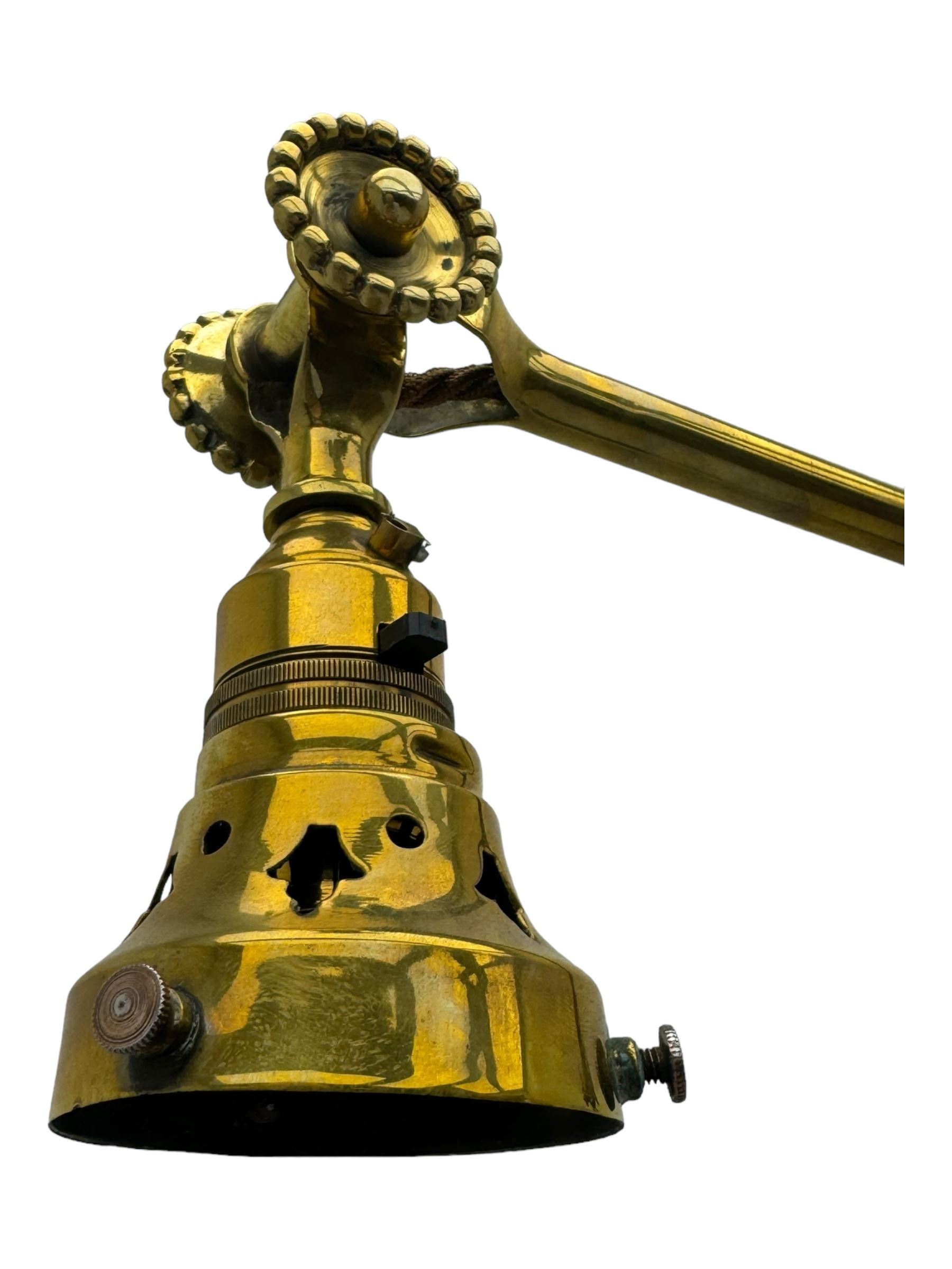 Early 20th century brass adjustable floor lamp, Royal Doulton decorative ceramic base embellished with raised floral and scroll patterns, stamped, brass column and adjustable arms terminating in brass bulb holder