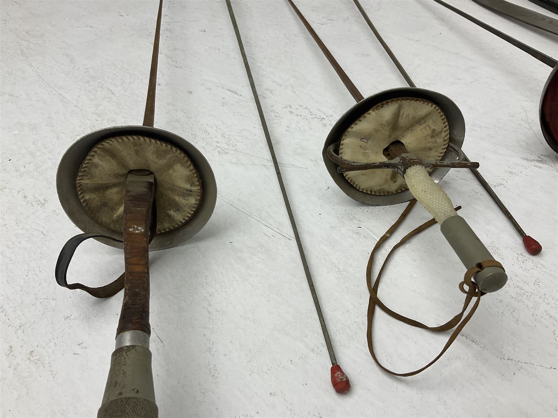 20th century Indian Tulwar sword with 71cm plain curving steel blade and iron hilt with extended langets, knopped grip and spiked pommel; in canvas covered wooden scabbard L87.5cm overall; together with five fencing swords comprising four foils and one epee, three marked Leon Paul, one in carrying case (6)