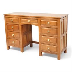 Craftsman made - elm kneehole dressing table, rectangular top over nine drawers, panelled sides, on stile supports 
