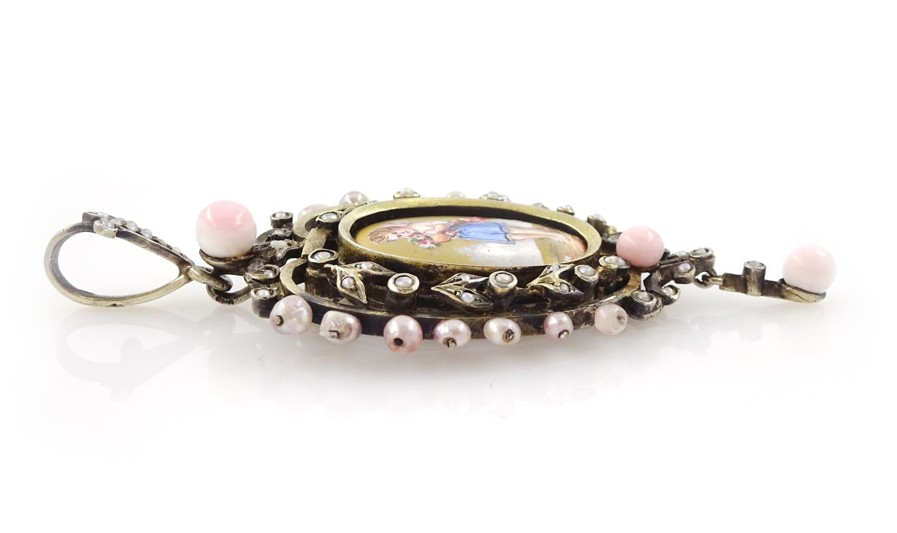 19th century silver pearl locket pendant, set with an oval painted enamel plaque of a cherub holding flowers, within an openwork pearl set surround