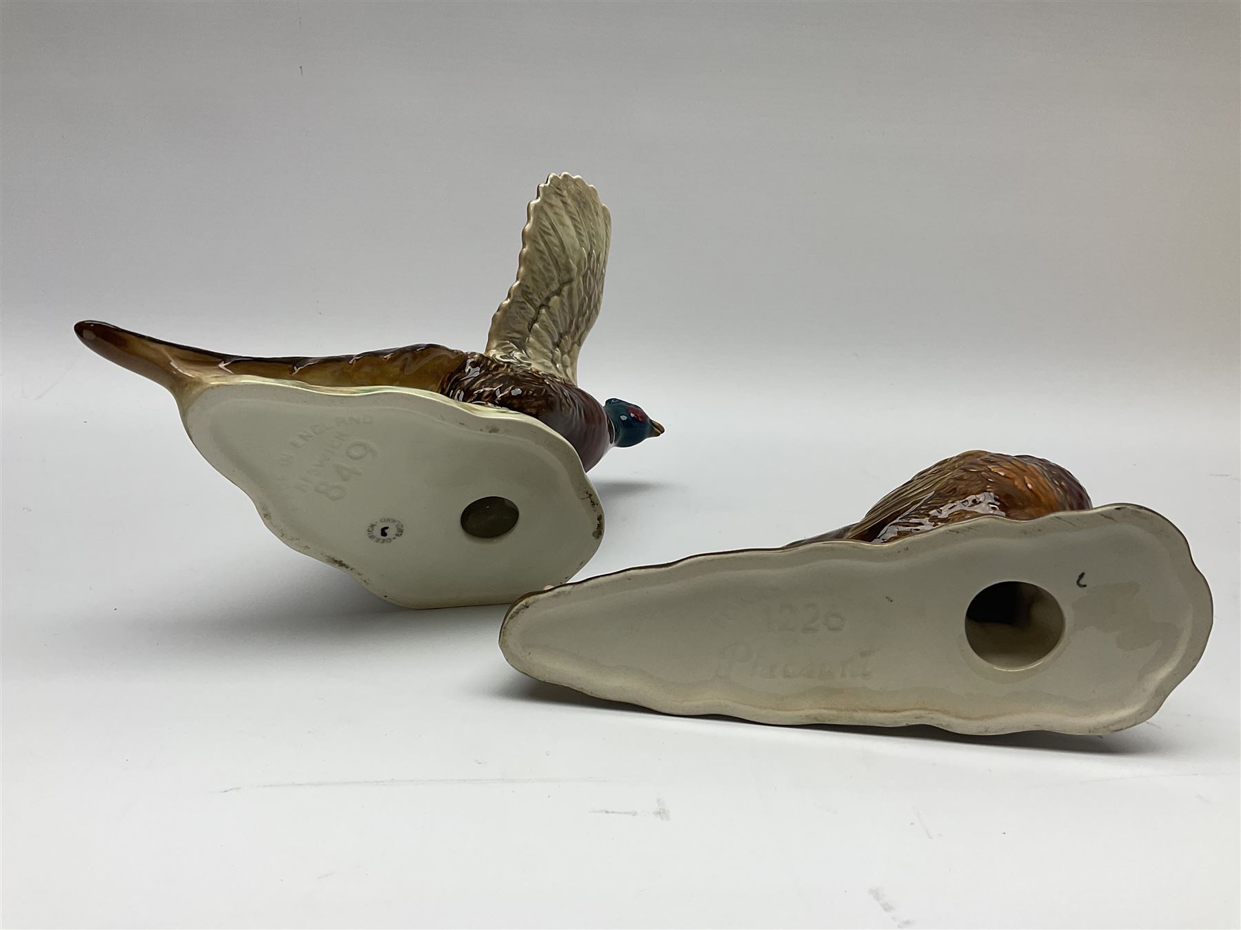 A collection of Beswick figures, comprising ginger cat model no 1898, ginger Persian kitten model no 1886, pheasant in flight model no 849, and pheasant model no 1226b.  