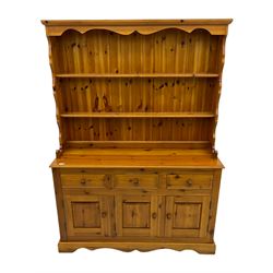 Pine farmhouse dresser with three drawers and three cupboards, and two tier plate rack