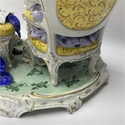 20th century Naples figure group, modelled as a seated female figure playing the lute seated, before a male figure stood holding a sheet of music, each in period dress, upon an oval base with gilt heightened scroll edge, with crowned N mark beneath, H31.5cm L33cm
