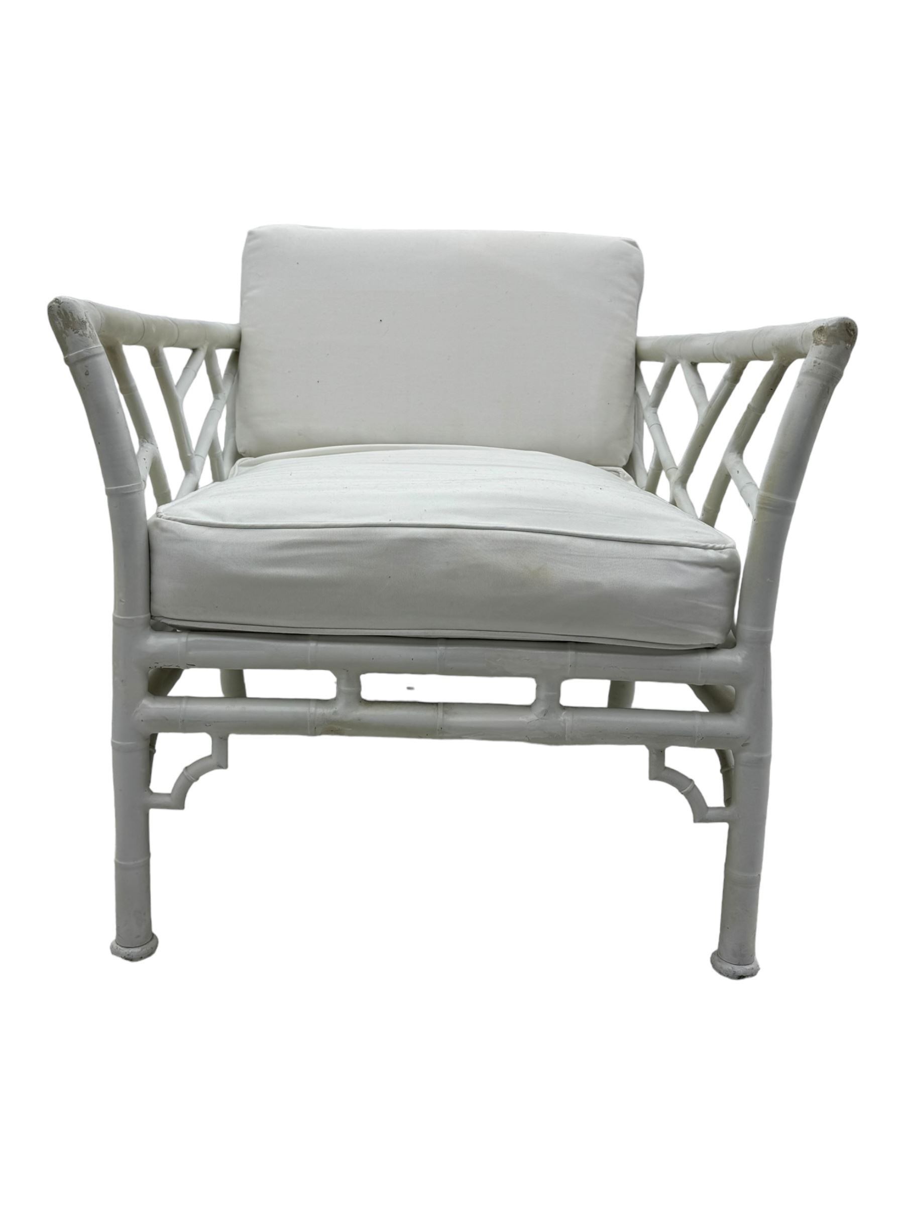 Late 20th century faux bamboo conservatory sofa, white painted frame with geometric openwork back and sides, loose cream cushions, on cylindrical supports (W134cm, D76cm, H80cm); matching armchair (W75cm, D76cm, H80cm); matching coffee table with glass insert (W46cm, D45cm, H36cm)