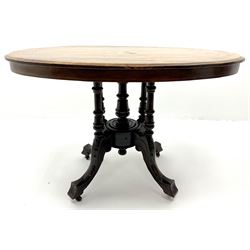 Edwardian inlaid walnut oval pedestal salon table, four turned supports joined by central finial on acanthus carved shaped supports 