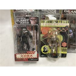 Sixteen carded action figures comprising seven 'Gears of War'; four 'Hitchhikers Guide to the Galaxy'; two 'Torchwood'; 'Planet of the Apes'; 'Bruce Lee'; and 'Assassin's Creed'; all in unopened packs (16)
