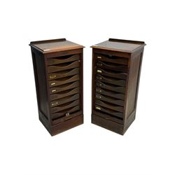 Two early 20th century mahogany tambour cabinets, each with retractable roll-top front revealing fitted interior with concave-front filing drawers and brass fittings