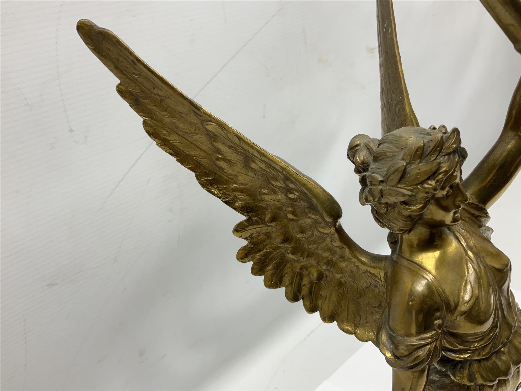 After Oswald Schimmelpfennig (German, 1872-1939): Pair of gilt bronze winged Allegorical female figures, the first example with arm outstretched holding a branch, signed 'Schimmelpfennig 1900', the second with arm raised above her head holding a book and sword in the other, both raised upon marble plinths, H45cm