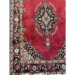 Persian rug, the red ground field decorated with floral design medallion and spandrels, guarded border with repeating floral design
