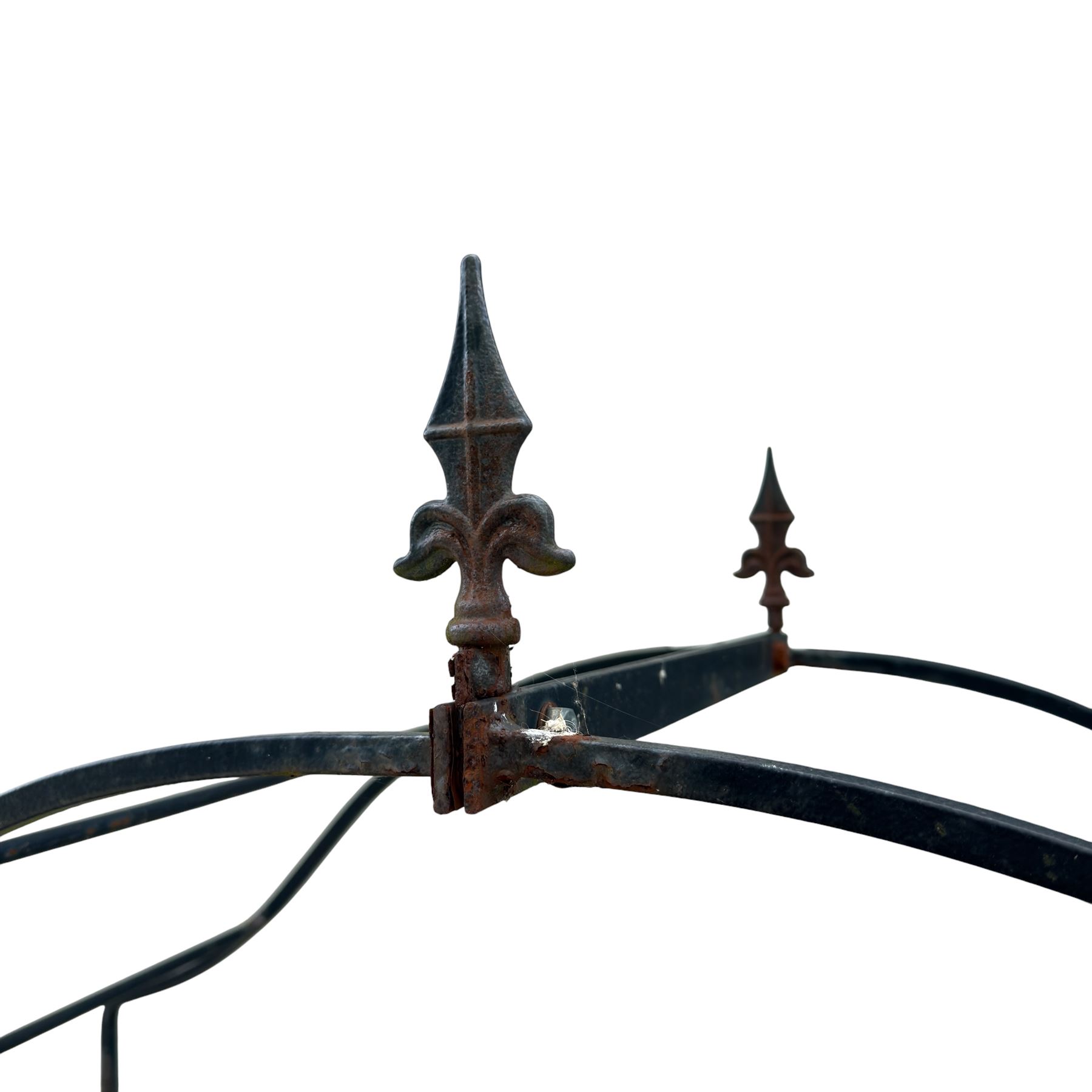 Antique wrought iron strapwork garden arch, with scroll form arched top with spearhead finials, over integral side trellis panels, in distressed black-painted finish