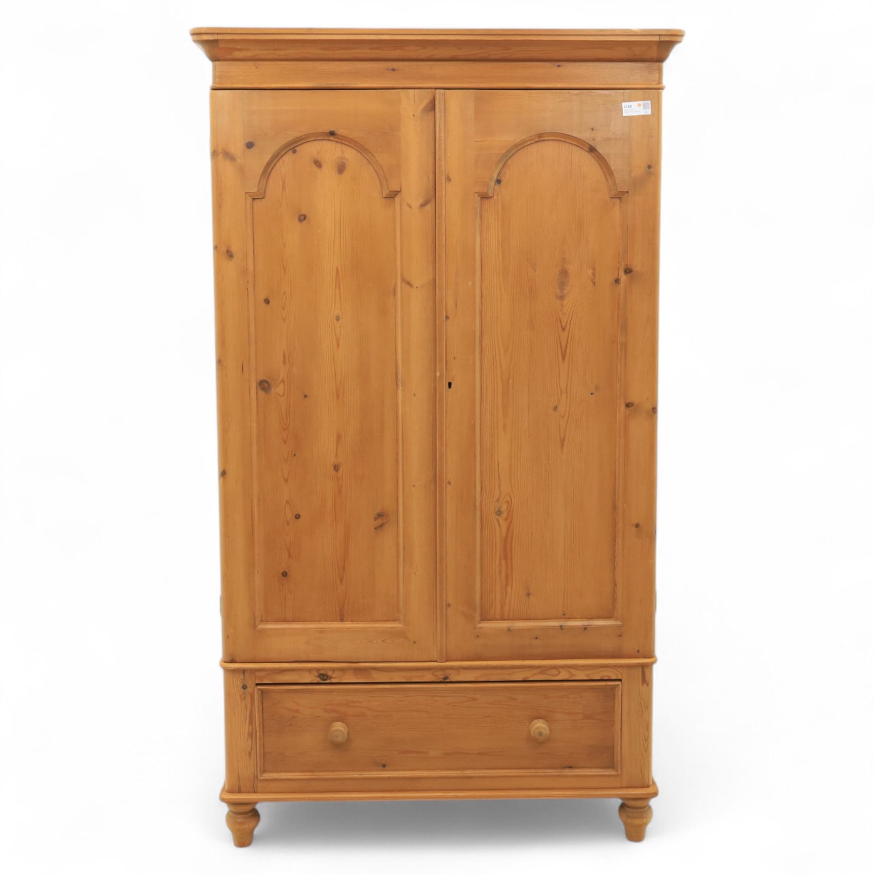 Two contemporary traditional-style wardrobes, projecting plain cornice above two arched moulded panel doors, above a full-width drawer fitted with turned wooden handles, raised on turned bun feet