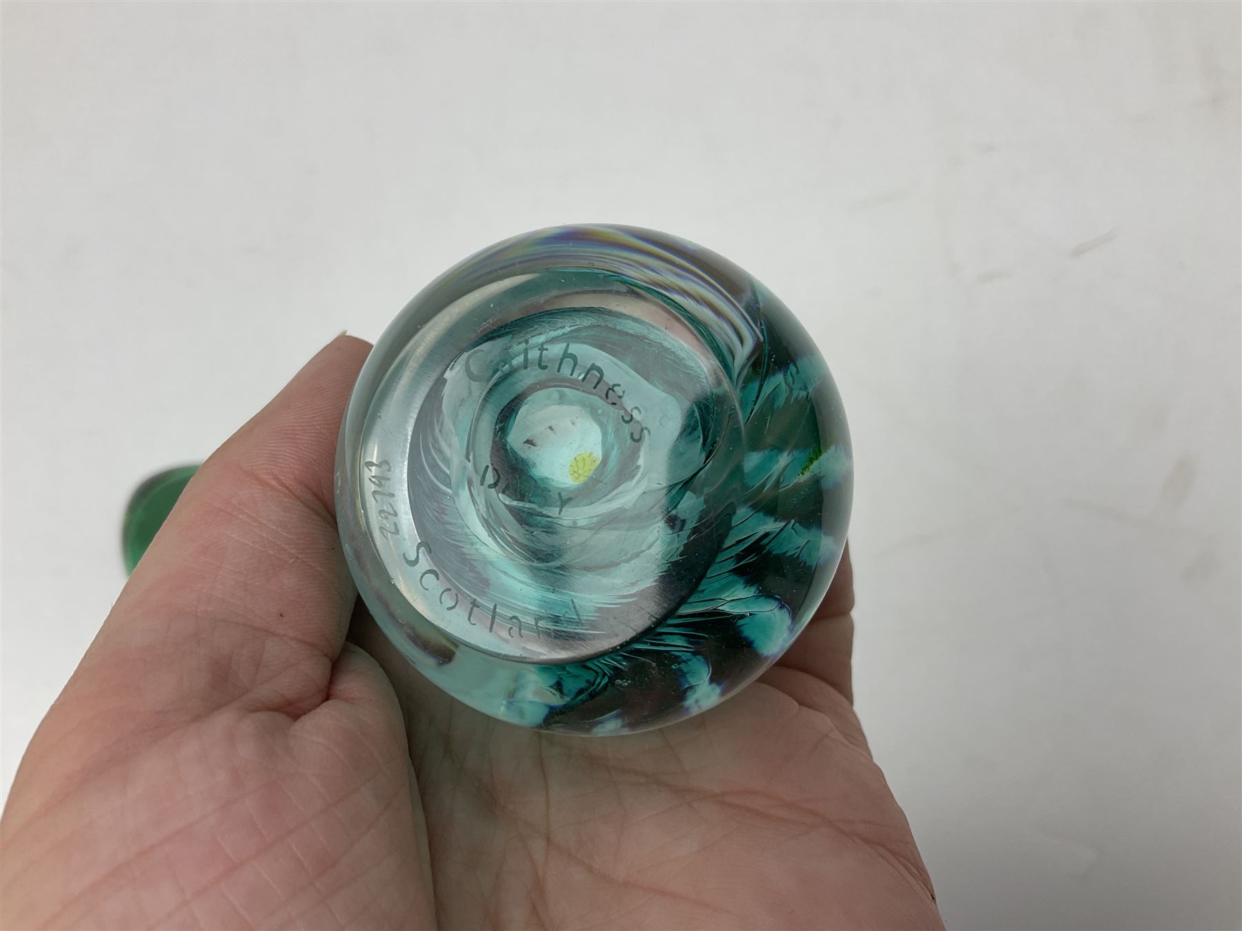 Three millefiori paperweights, together with a green glass dump paperweight with air bubble inclusions, Caithness Daisy and Cauldron paperweights and two small Caithness glass vases, tallest H9cm