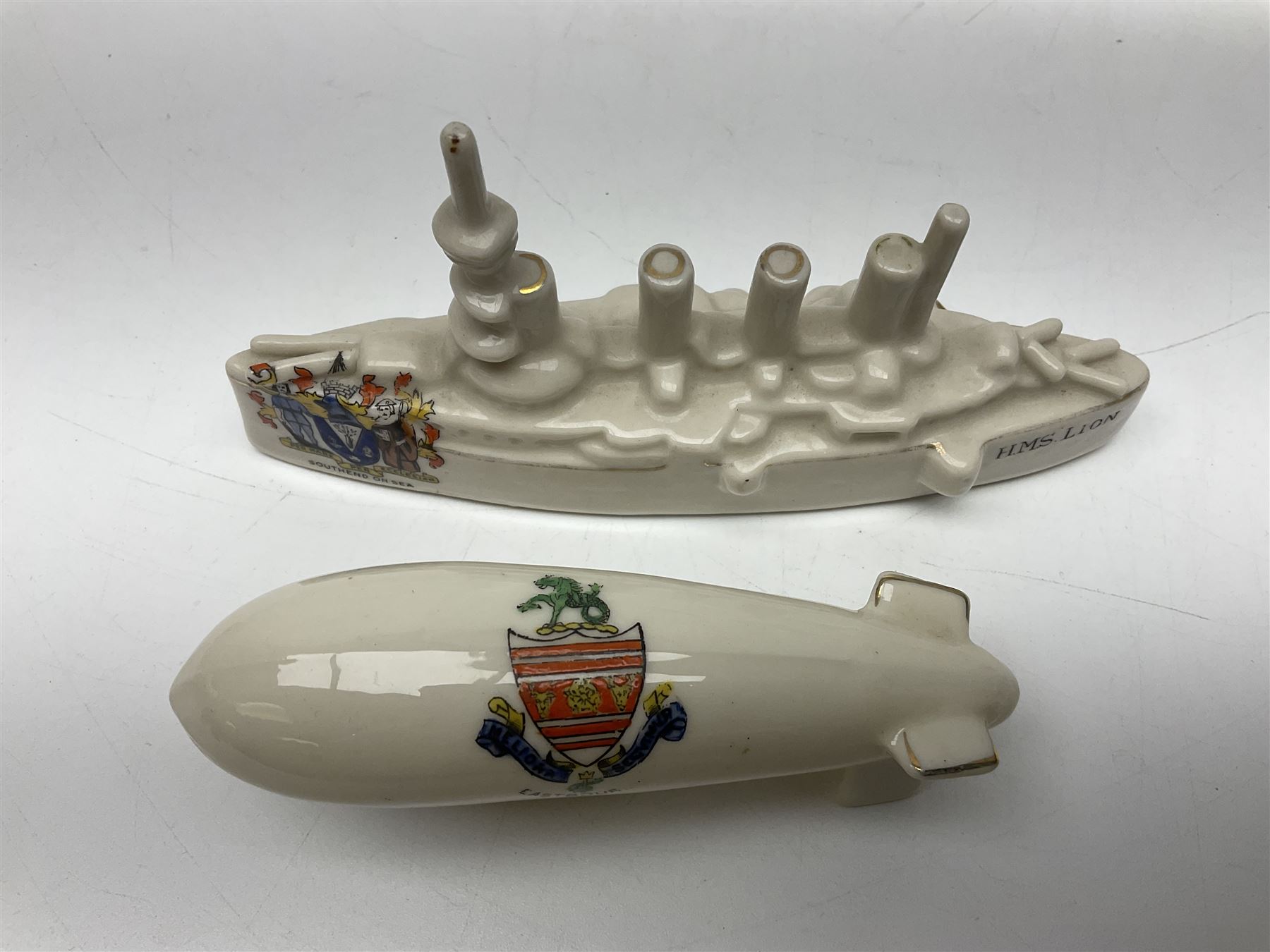 Ten WW1 crested china military models comprising submarine, four ships including Lusitania, four Zeppelins/balloons and an aircraft; various makers including Arcadian China, Swan China, Carlton China, Waterfall, Grafton China etc; various crests including Saint Neots, Great Yarmouth, Tewksbury, Swanage, Simons Town, Hull etc (10)