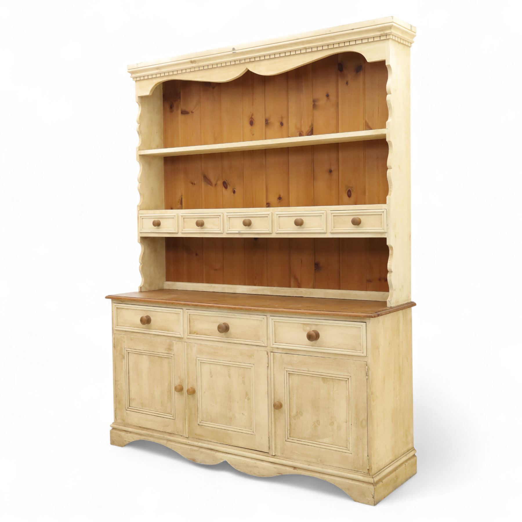 20th century painted pine dresser, moulded cornice above shaped frieze and two open plate shelves, central row of five small drawers with wooden knobs, base fitted with three drawers over a pair of panelled cupboard doors, on shaped plinth base