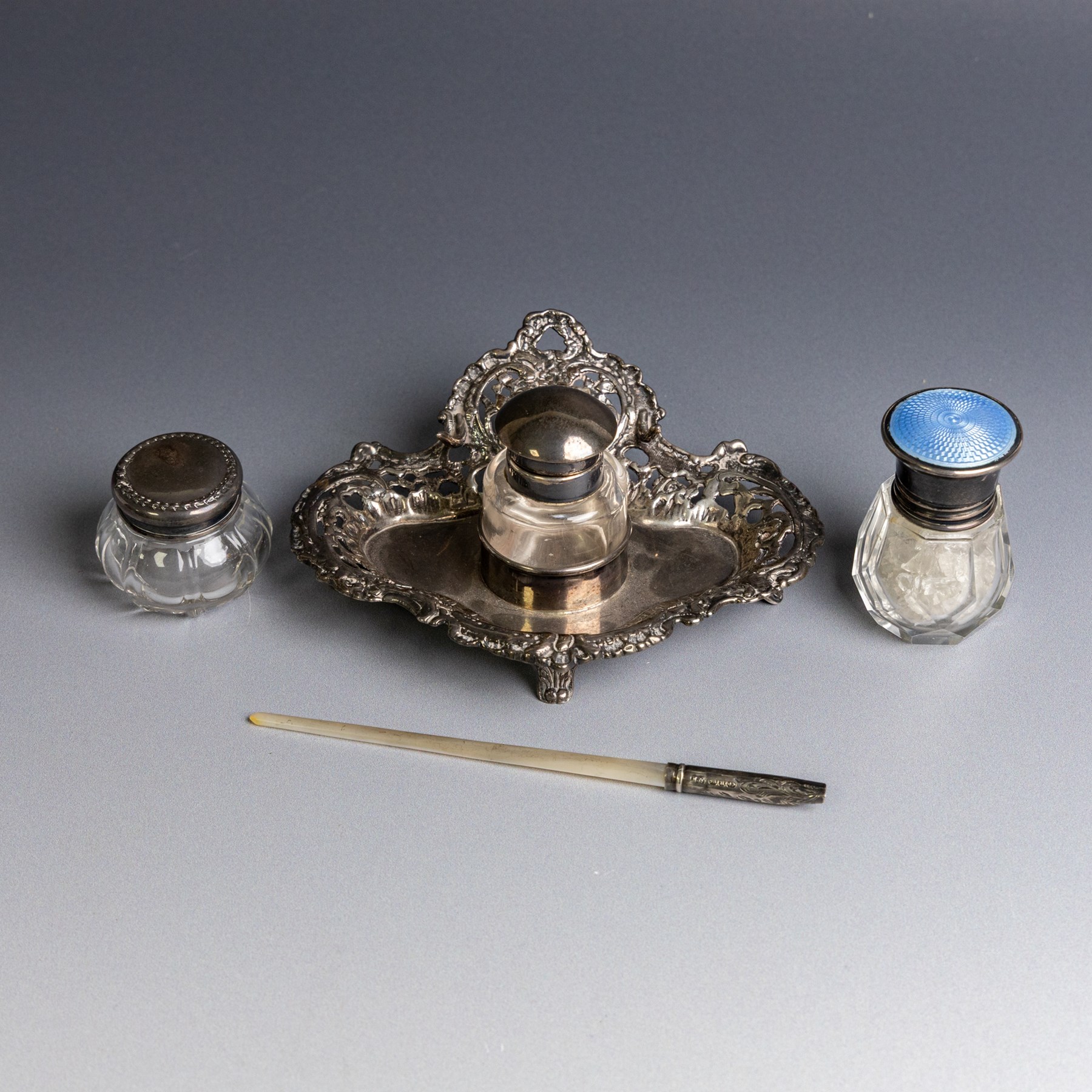 Victorian silver inkwell stand, with silver topped inkwell, hallmarked Lawrence Emanuel, Birmingham 1893, together with a mother of pearl dip pen with silver collar and two silver topped jars, one with guilloche enamel decoration, all hallmarked