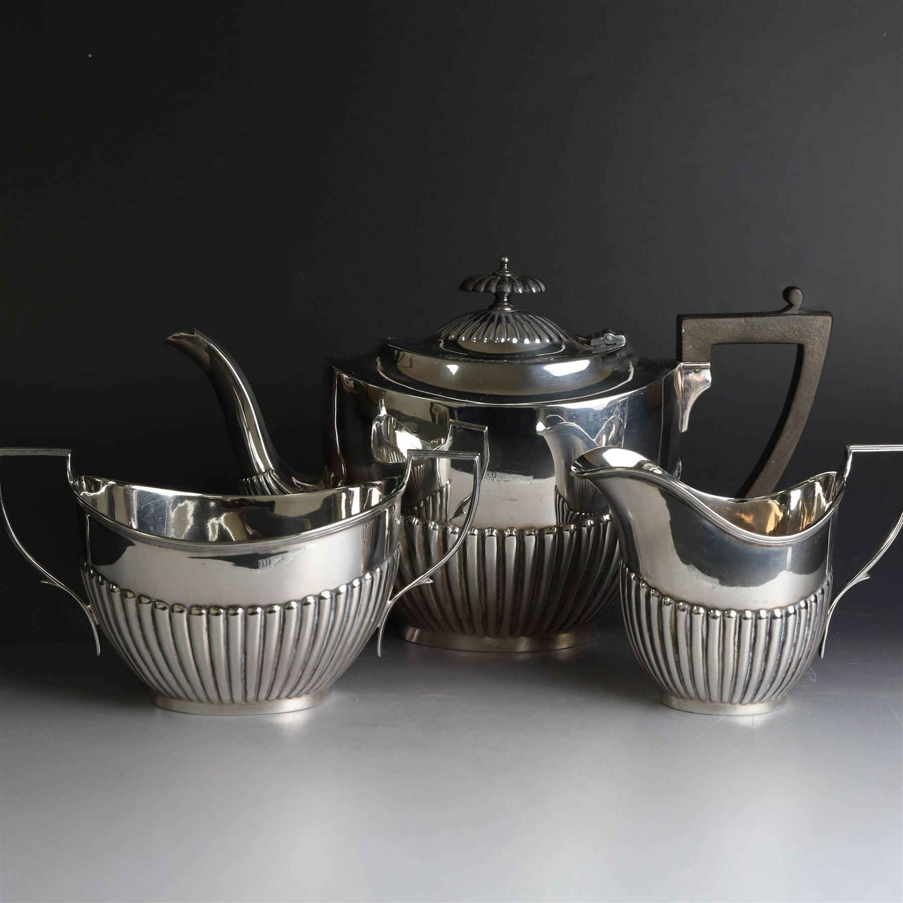 1920s silver three piece tea service, comprising teapot, twin handled open sucrier and milk jug, each of oval part fluted form, the teapot with Bakelite type handle and finial, hallmarked Cooper Brothers & Sons Ltd, Sheffield 1922