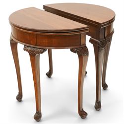 Pair of Victorian mahogany demi-lune card tables, the lunette shaped fold-over top enclosing purple-baize lined interior and supported by gate-leg action, banded frieze over cabriole supports with scrolling acanthus leaf knees, terminating to scrolled foliate feet