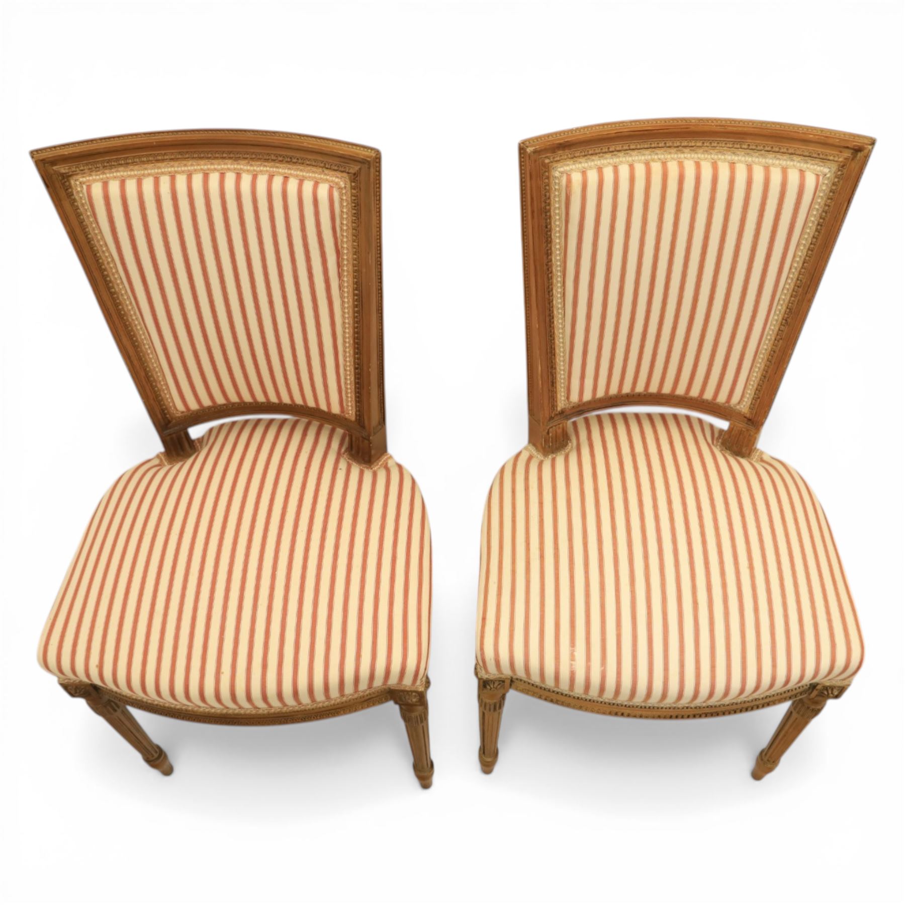 20th century Louis XVI style beech salon suite, comprising settee and four chairs, the settee with shaped rectangular back and upholstered arms over a shaped seat, the chairs with rectangular backs and overstuffed seats, each upholstered in striped fabric with close-nailed borders, upon fluted tapering supports headed by carved paterae, terminating in toupie feet, chairs H89cm W47cm