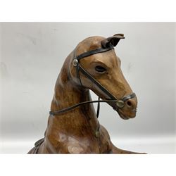 Leather covered horse figure, together with carved wood rhinoceros figure and cat modelled stretching, horse 41cm (3)