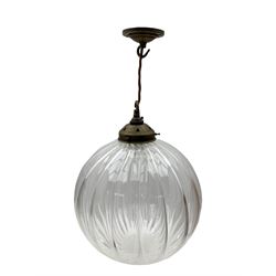 Set of two small and two large pendant lights, each with clear glass spherical shade with moulded swirl pattern, suspended from twisted cords, brass ceiling rose